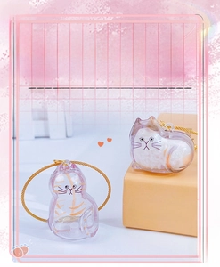 Detail of cat-shaped clear capsule pendants with gold cords for pet fur storage