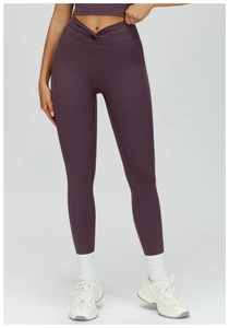 Detail of high waisted yoga pants in dark purple with a stylish front cross twist design