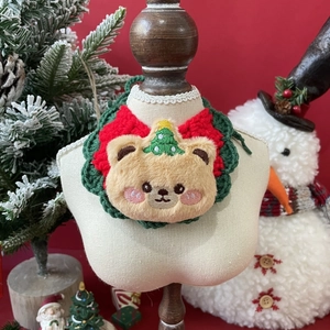 Detail of Christmas pet bib featuring brown plush bear and festive knit holiday pattern