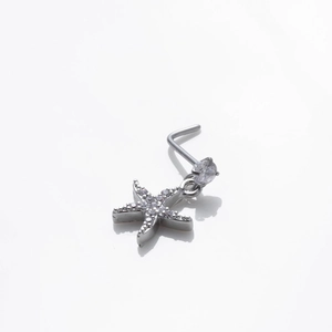 Détail d'un piercing de nez en L avec pendentif étoile et zircons brillants incrustés