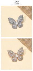 Detailed macro view of crystal butterfly brooches with white pearls in gold and silver