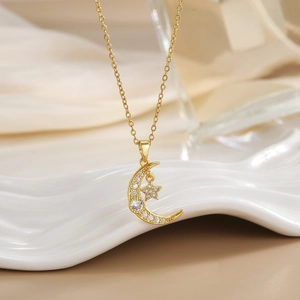 Macro detail of gold plated moon and star pendant with sparkling zircon micro-inlay