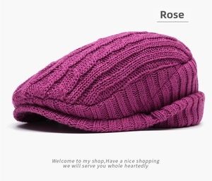Close-up of rose knit beret featuring thick cable knit texture and folded brim detail
