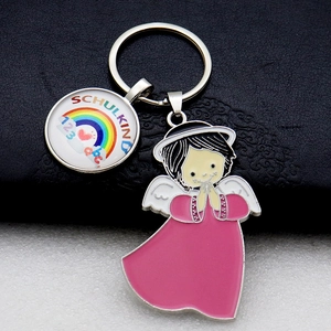 Detail of metal rainbow keychain with Schulkind round charm and a pink angel pendant