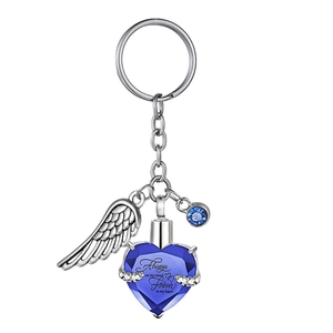 Detail of silver angel wing and blue heart urn keychain with memorial engraving