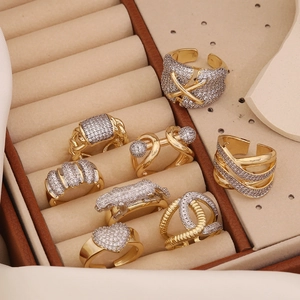 Collection détaillée de bagues dorées avec zircons blancs sur un coffret en cuir
