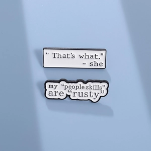 Minimalist white enamel pins set with funny quotes on a clean blue background