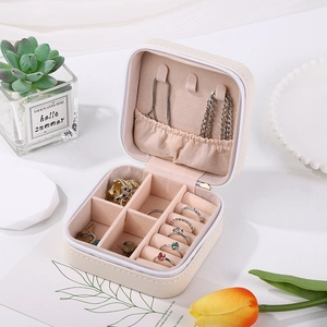 Portable jewelry box detail showing necklace hooks and ring slots in beige finish