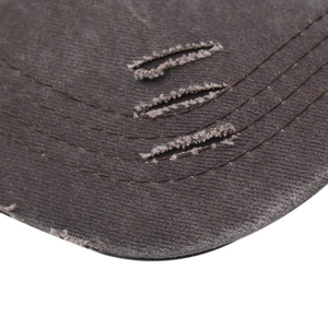 Macro view of distressed washed charcoal denim baseball cap with frayed edges and stitching