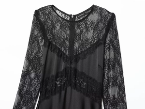 Close-up of elegant black lace拼接 neckline with brand tag on a long sleeve dress