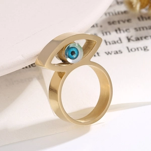 Goldener Hip-Hop-Ring mit blauem Teufelsauge-Edelstein auf dekorativem Hintergrund