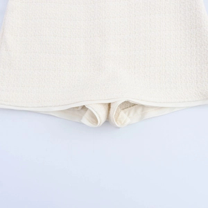 Chic cream tweed skort set detail showing textured fabric and smooth inner lining