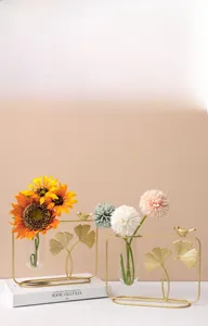 Detail view of golden ginkgo leaf iron frame and clear glass test tube vase for hydroponics