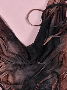Détail du tissu plissé dégradé sur la robe dos nu avec col licou et capuche