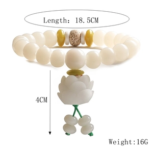 Detailed macro view of white bodhi seed prayer bracelet with carved lotus charm pendant