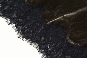 Dettaglio in velluto verde scuro unito a un delicato pizzo nero a ciglia rifinito