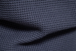 Detailed macro view of dark navy waffle knit texture showing the thick weave and fabric