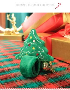 Detail of green plush Christmas tree slap bracelet with colorful embroidery on red background