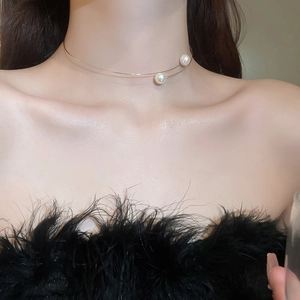 Detail of a minimalist gold double-layer choker necklace with elegant white pearls