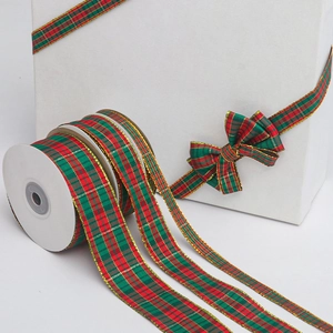 Detail of red and green plaid Christmas ribbon with gold edges on gift box bow