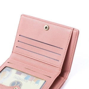 Detail of pink pebbled leather wallet featuring card slots and clear ID window