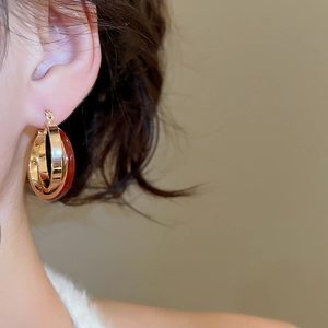 Close-up of vintage red crossover hoop earrings worn by model for elegant styling