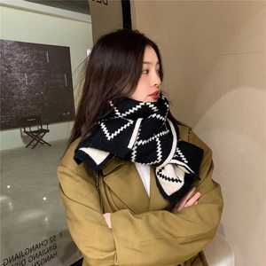 Classic black and white checkered knit scarf paired with a beige trench coat