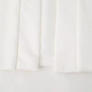 Close-up of white sleeveless padded vest featuring detailed horizontal ribbed texture
