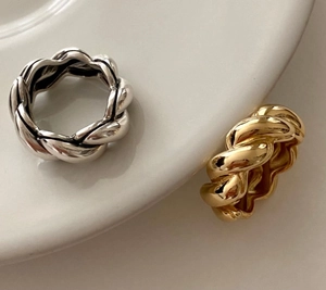 Close-up of a minimalist 925 silver ring with diagonal woven texture and metallic luster