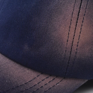 Close-up of high-density twill cotton fabric and stitch detail on washed baseball cap