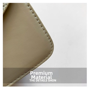 Macro detail of beige lychee textured leather with precise fine stitching on small bag