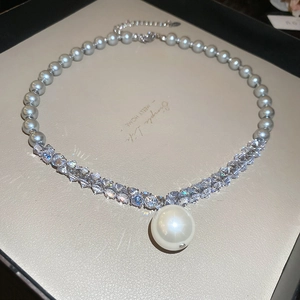 Detail of grey pearl necklace with sparkling crystals and white pearl pendant in box