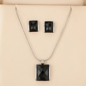 Detail of luxury square black crystal jewelry set with necklace and earrings in beige box