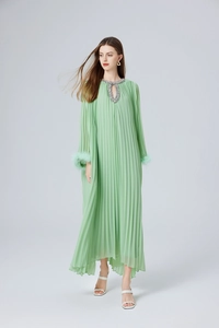 Détail d'une robe longue plissée vert menthe avec col à paillettes et plumes aux poignets