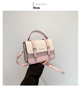 Detailed shot of pink and white color-block crossbody bag with gold metal buckle