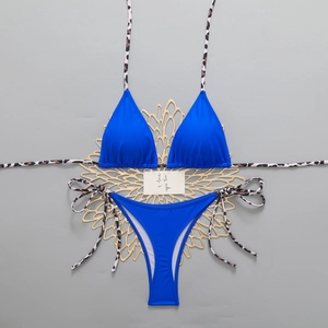 Detail of royal blue bikini with leopard print straps and adjustable tie-side bottoms