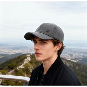 Detail view of a men's winter baseball cap featuring a silver metal shield logo and textured fabric