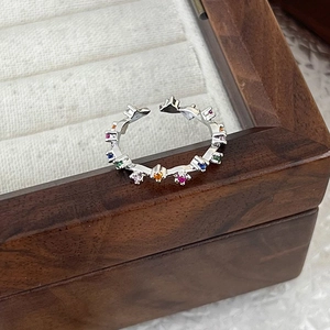 Detailed macro of a colorful micro-pave zircon crown ring on a premium wood jewelry box