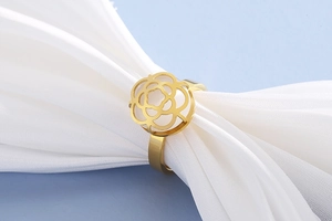 Macro view of gold stainless steel ring featuring a detailed hollow camellia flower design
