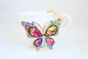 Macro detail of golden butterfly keychain with colorful sparkling crystal wings