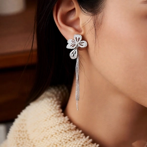 Close-up of elegant flower tassel earrings with zircons and pearls on a model