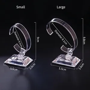 Clear acrylic watch display stand with C-shaped holder and thick base on black background
