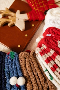 Close-up of thick coral fleece Christmas socks with festive patterns and soft plush texture