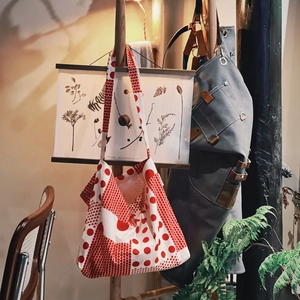 Sac fourre-tout en toile à pois rouges et blancs suspendu sur un support en bois