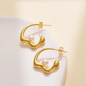 Elegant gold irregular lava earrings with white pearls on a minimalist white tray