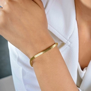 Detail of 18k gold plated stainless steel bracelet with fish scale texture on wrist