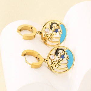 Detailed close-up of golden tropical earrings featuring palm tree, dolphin and pearl