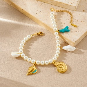 Bracelet de perles chic avec pendentifs coquillage corail et nautile doré sur pierre