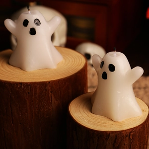 Ghost shaped Halloween candles on rustic wood base with a spooky decorative background