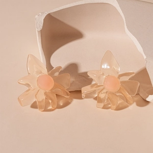 Detail of translucent resin flower earrings with pink center on a minimalist beige base